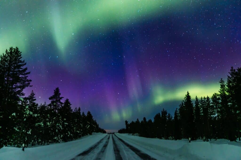 Northern lights Aurora Borealis activity over the road in Finland, Lapland